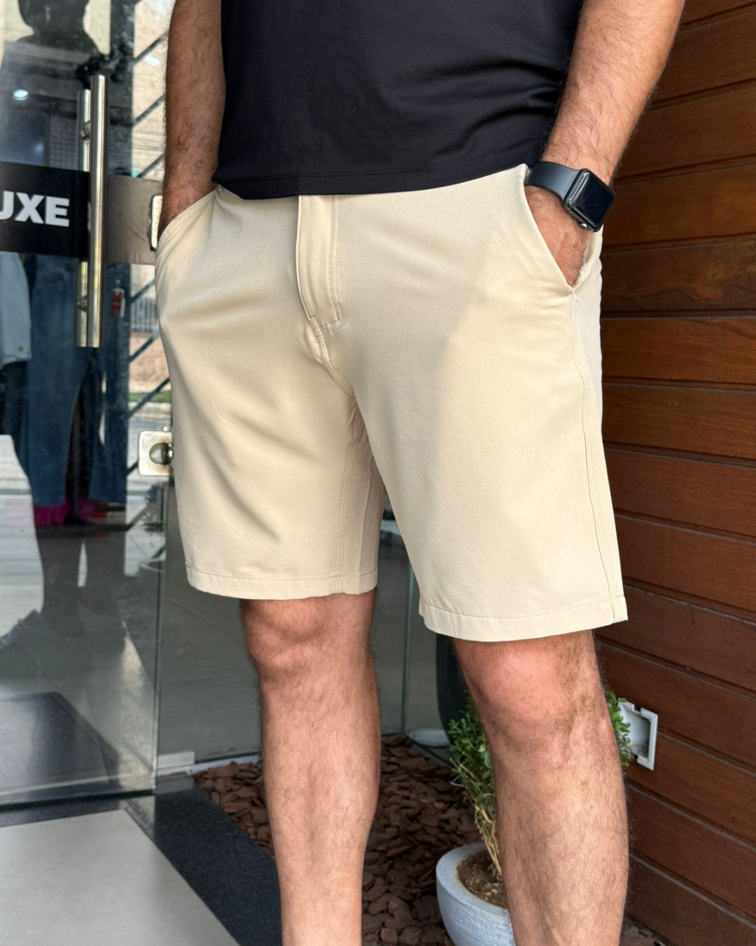 Homem usando bermuda masculina comfy em sarja bege, com bolsos frontais e modelagem reta, em look casual.