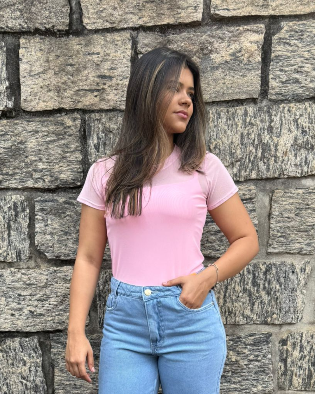 mulher-usando-blusa-de-tule-feminina-rosa-claro-com-manga-curta-e-jeans-claro