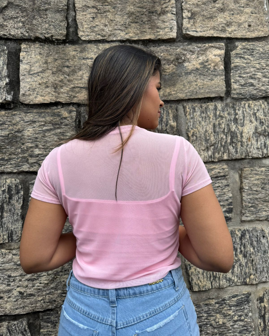 mulher-usando-blusa-de-tule-feminina-rosa-claro-com-manga-curta-e-jeans-claro