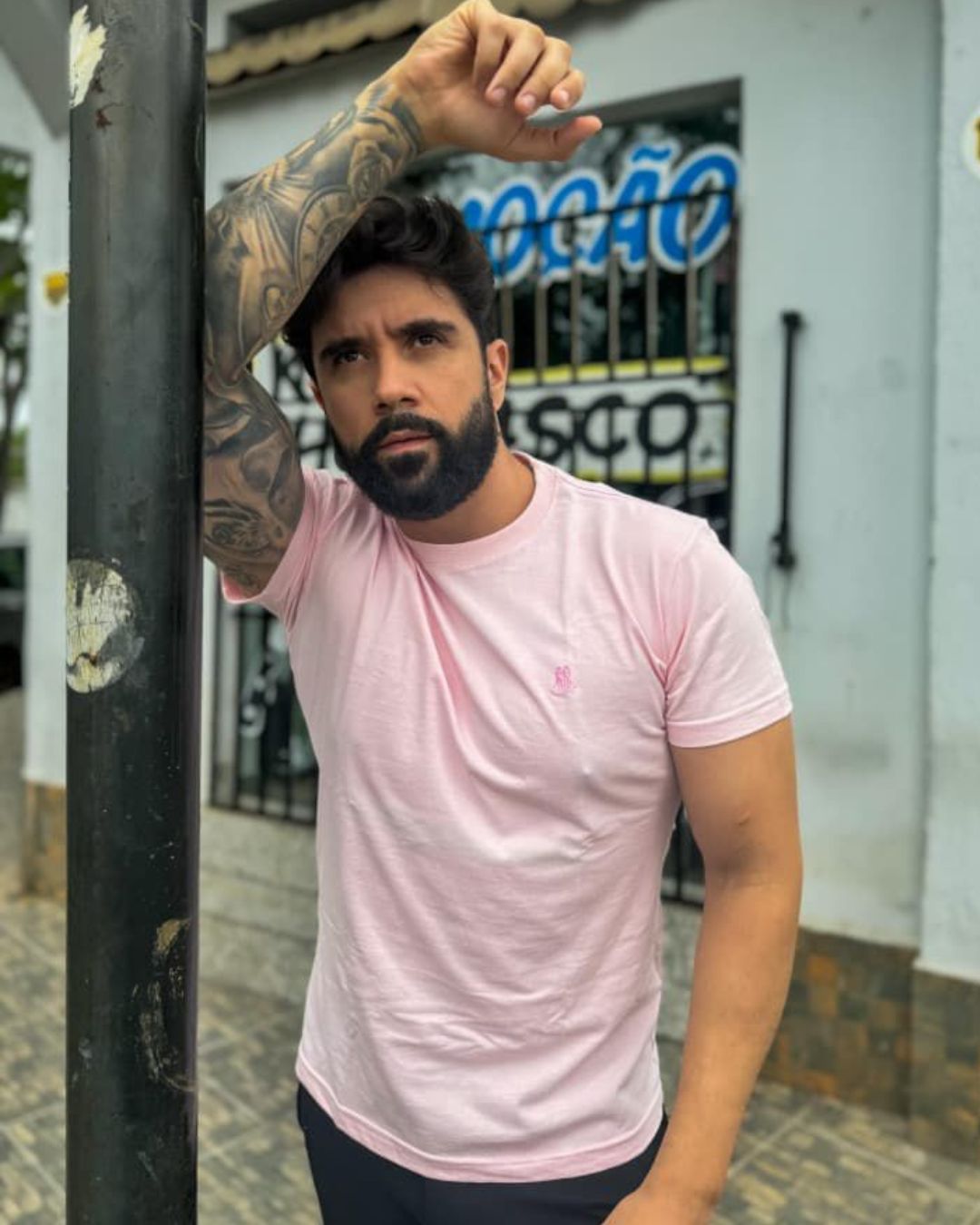 homem-usando-camiseta-rosa-basica-masculina-gola-careca-em-ambiente-urbano