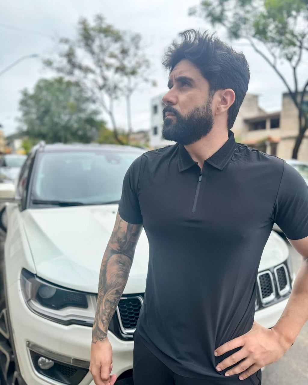 homem-usando-camisa-polo-preta-manga-curta-com-ziper-modelo-jacquard-em-ambiente-urbano