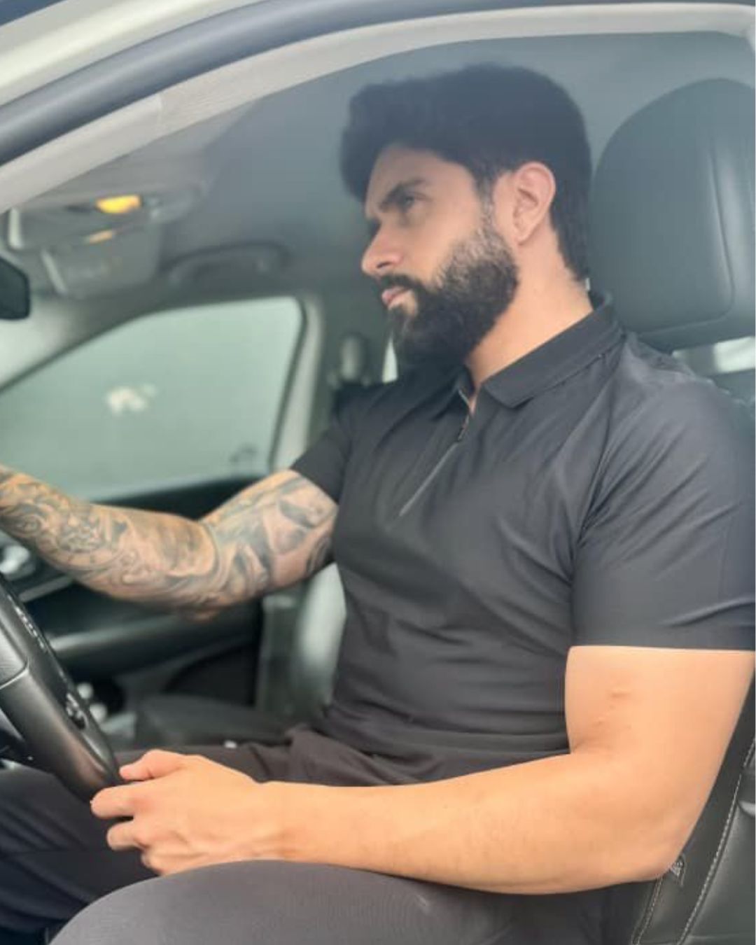 homem-usando-camisa-polo-preta-manga-curta-com-ziper-modelo-jacquard-em-ambiente-urbano